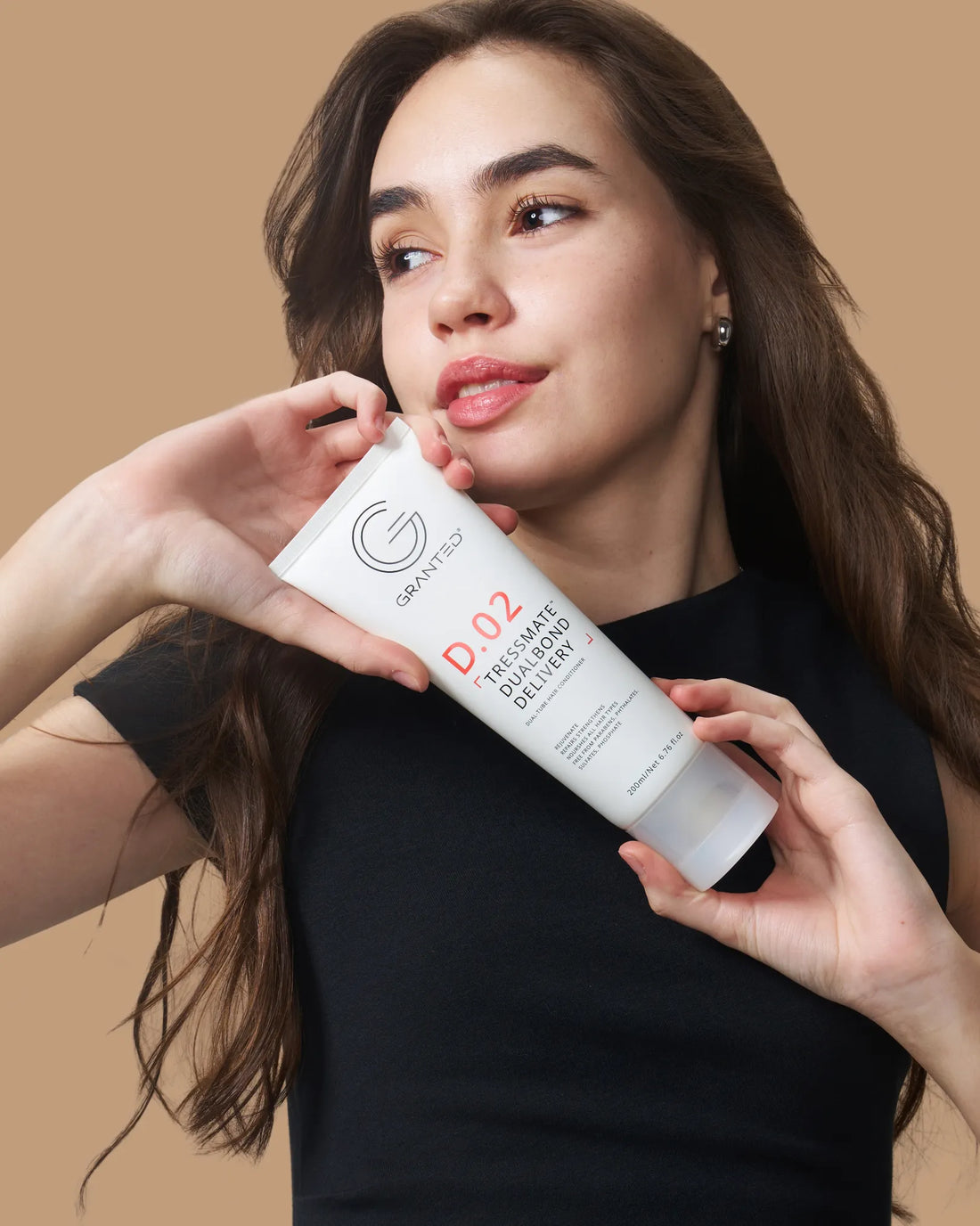 Model holding Granted D.02 Dualbond Conditioner for Bond Repair, showcasing dual-phase bond repair.